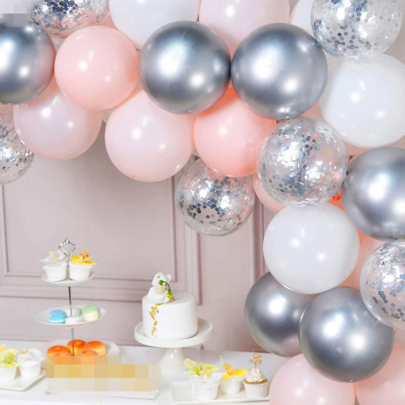 The Double Layered Pastel Pink, Silver and White Latex Balloon Garland Arch is composed of 60 pieces and is ideal for weddings, parties, and birthdays. The kit includes pink, white, and silver latex balloons, along with clear silver confetti balloons, allowing for a stunning balloon display. 